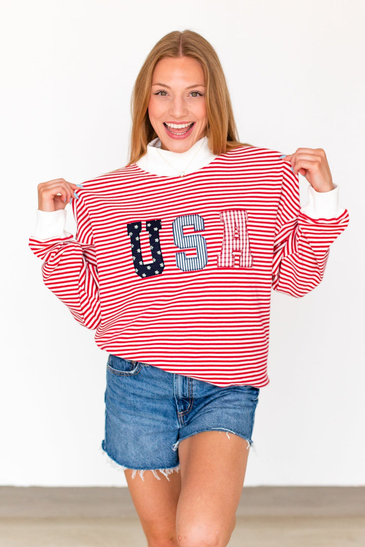 Person wearing a red and white striped sweater with &